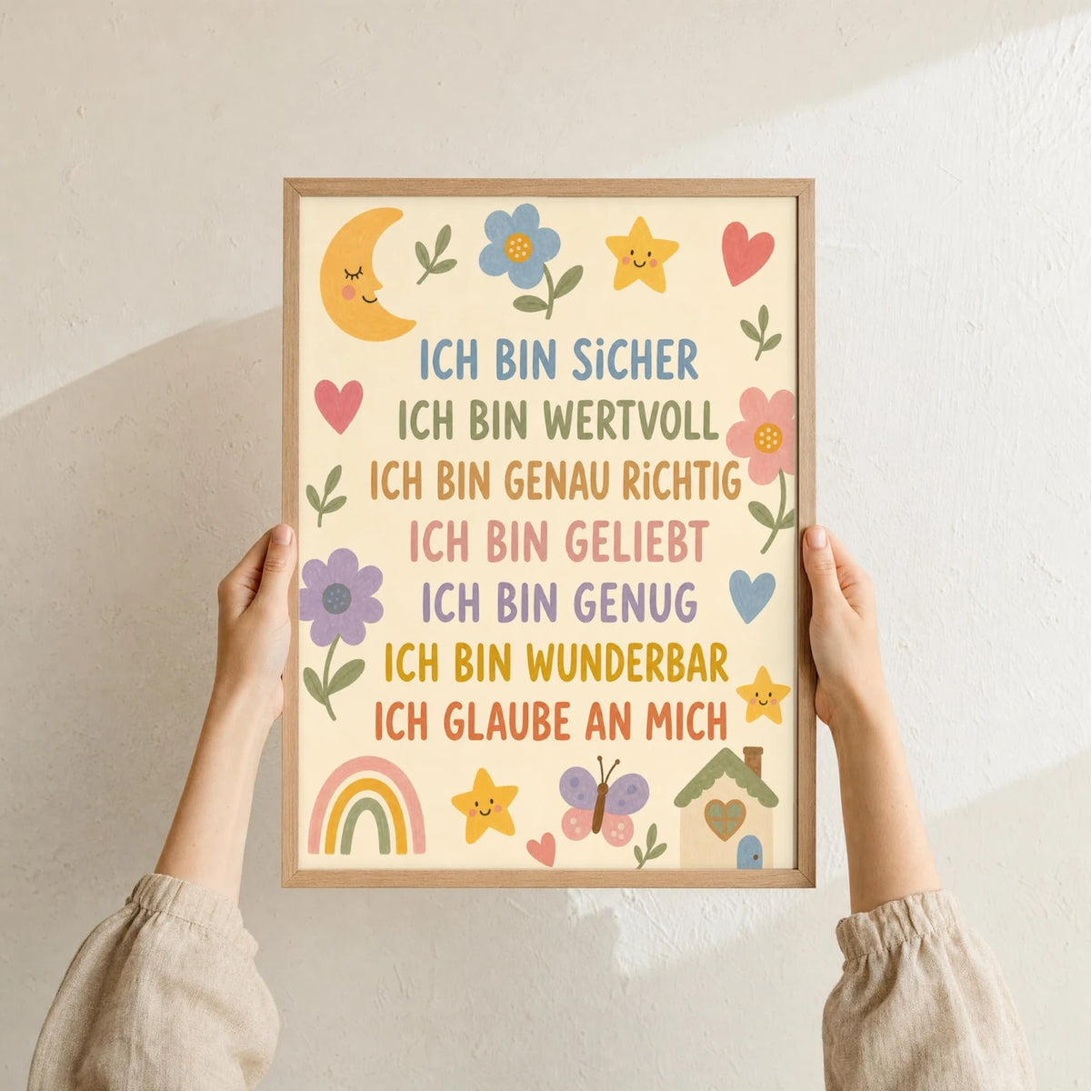 Affirmationsposter âBlumenwiese Ich bin sicherâ im Holzrahmen in den HĂ€nden gehalten â Taufgeschenk und Kinderzimmer Deko