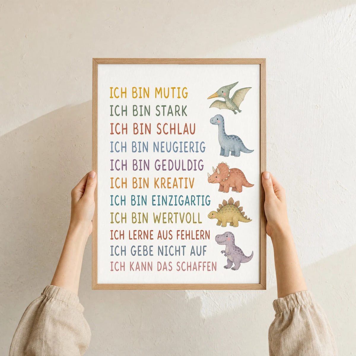Affirmationsposter âDinosâ im Holzrahmen in den HĂ€nden gehalten â Taufgeschenk und Kinderzimmer Deko