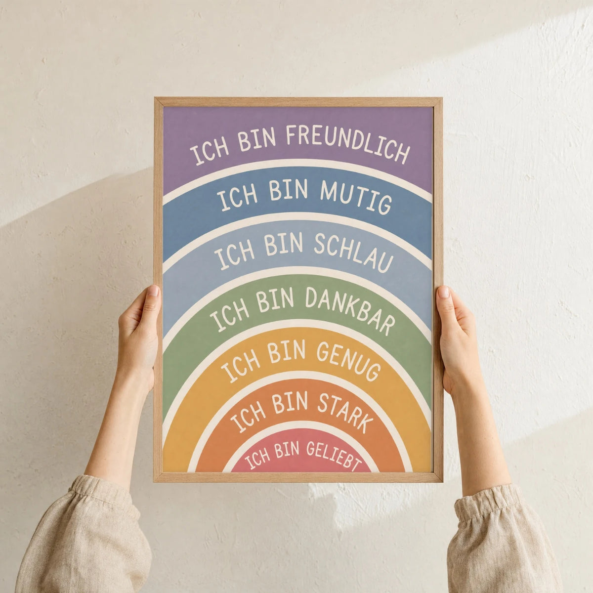 Affirmationsposter „Regenbogen Ich bin freundlich“ im Holzrahmen in den Händen gehalten – Taufgeschenk und Kinderzimmer Deko