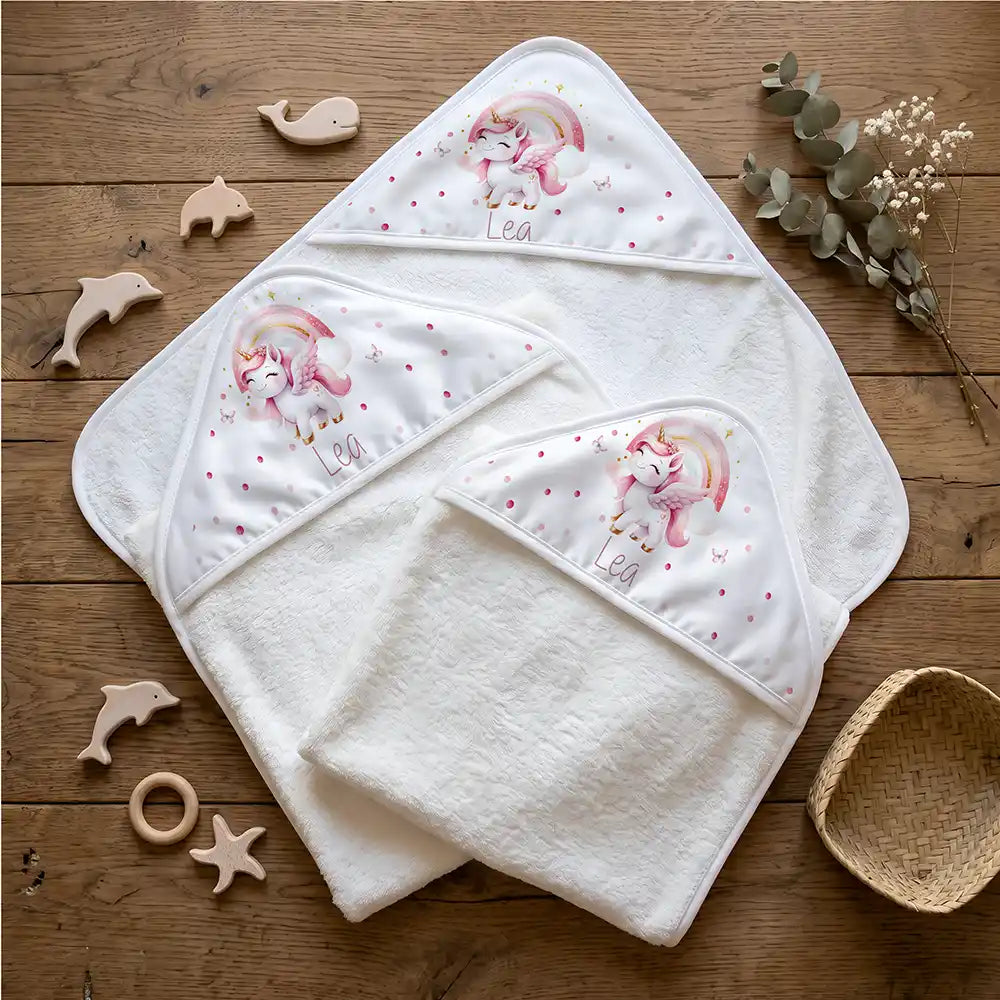 Personalisiertes Kapuzenhandtuch Baby Einhorn Rosa – Flatlay mit Eukalyptus und Beißring