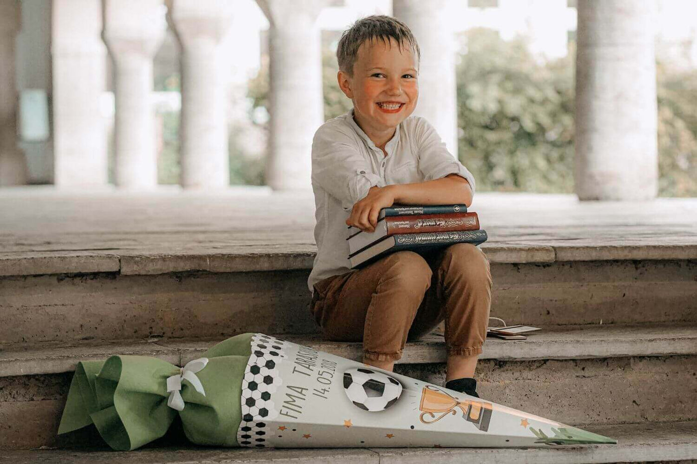 Kind freut sich am ersten Schultag über seine Einschulungsgeschenke