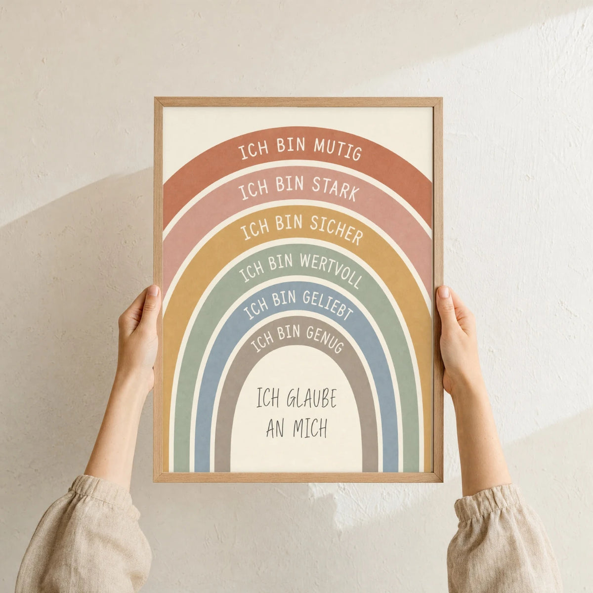 Affirmationsposter „Regenbogen Creme“ im Holzrahmen in den Händen gehalten – Taufgeschenk und Kinderzimmer Deko