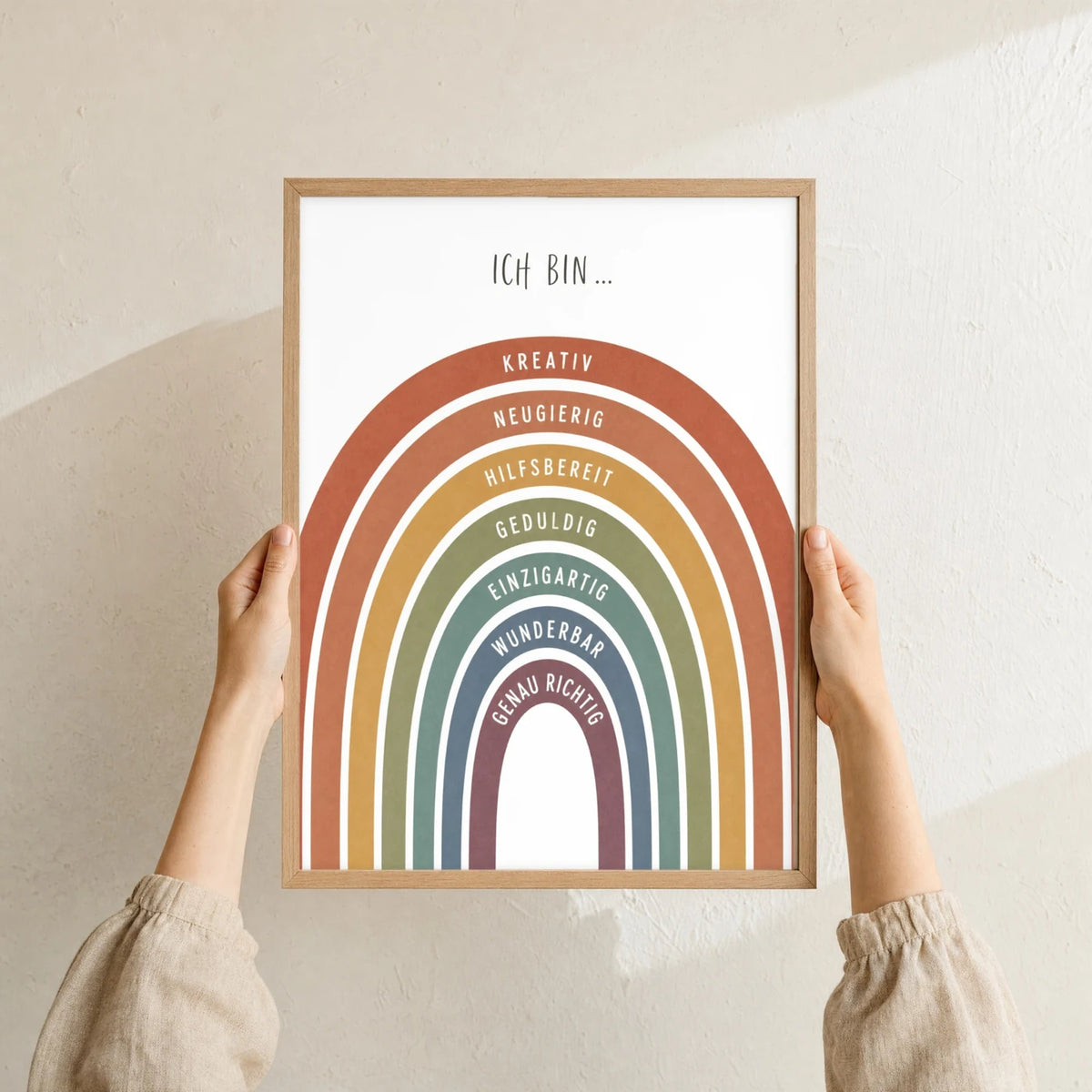 Affirmationsposter „Regenbogen Terracotta“ im Holzrahmen in den Händen gehalten – Taufgeschenk und Kinderzimmer Deko