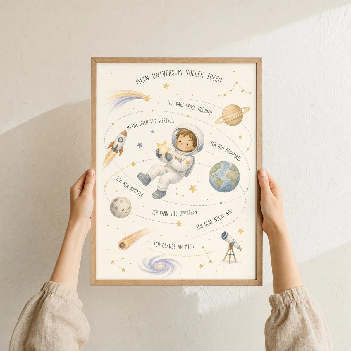 Affirmationsposter „Universum voller Ideen“ im Holzrahmen in den Händen gehalten – Taufgeschenk und Kinderzimmer Deko