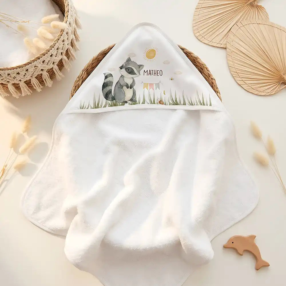 Personalisiertes Kapuzenhandtuch Baby Waschbär Wiese – Doppel-Flatlay mit Eukalyptus