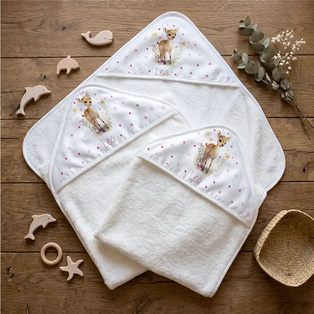 Personalisiertes Kapuzenhandtuch Baby Reh Wiese – Flatlay mit Eukalyptus und Beißring