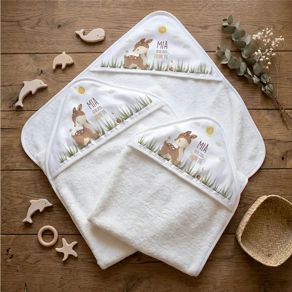 Personalisiertes Kapuzenhandtuch Baby Reh Geburtsdaten – Flatlay mit Eukalyptus und Beißring
