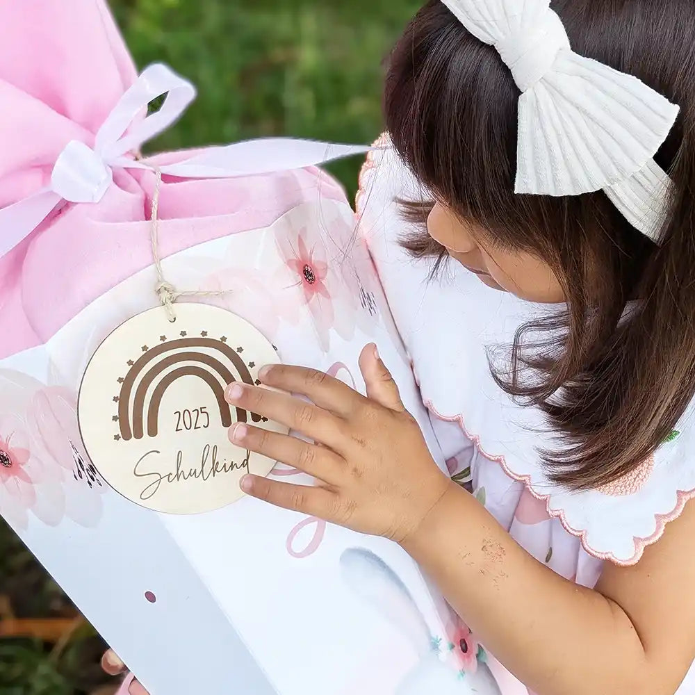 Rosa Schultüte mit Hasenmotiv und Namen personalisiert. Mädchen freut sich auf Einschulung 2025 mit ihrer Zuckertüte. Individuelles Geschenk zum Schulstart mit niedlichem Design und Holzanhänger.