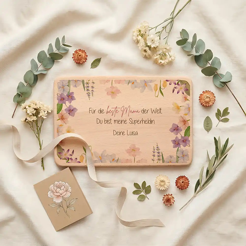 Personalisiertes Frühstücksbrettchen Muttertag Beste Mama Blütenstreuung – Geschenkszene auf gedecktem Tisch